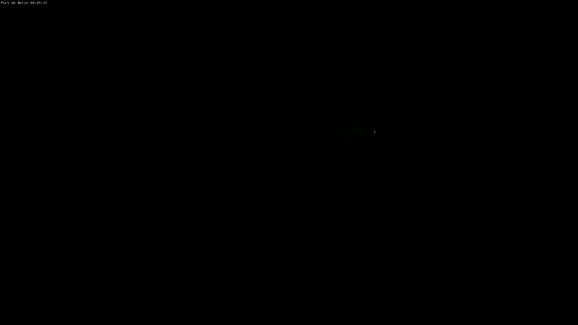A very faint, small light is visible in a pitch-black nighttime scene.
