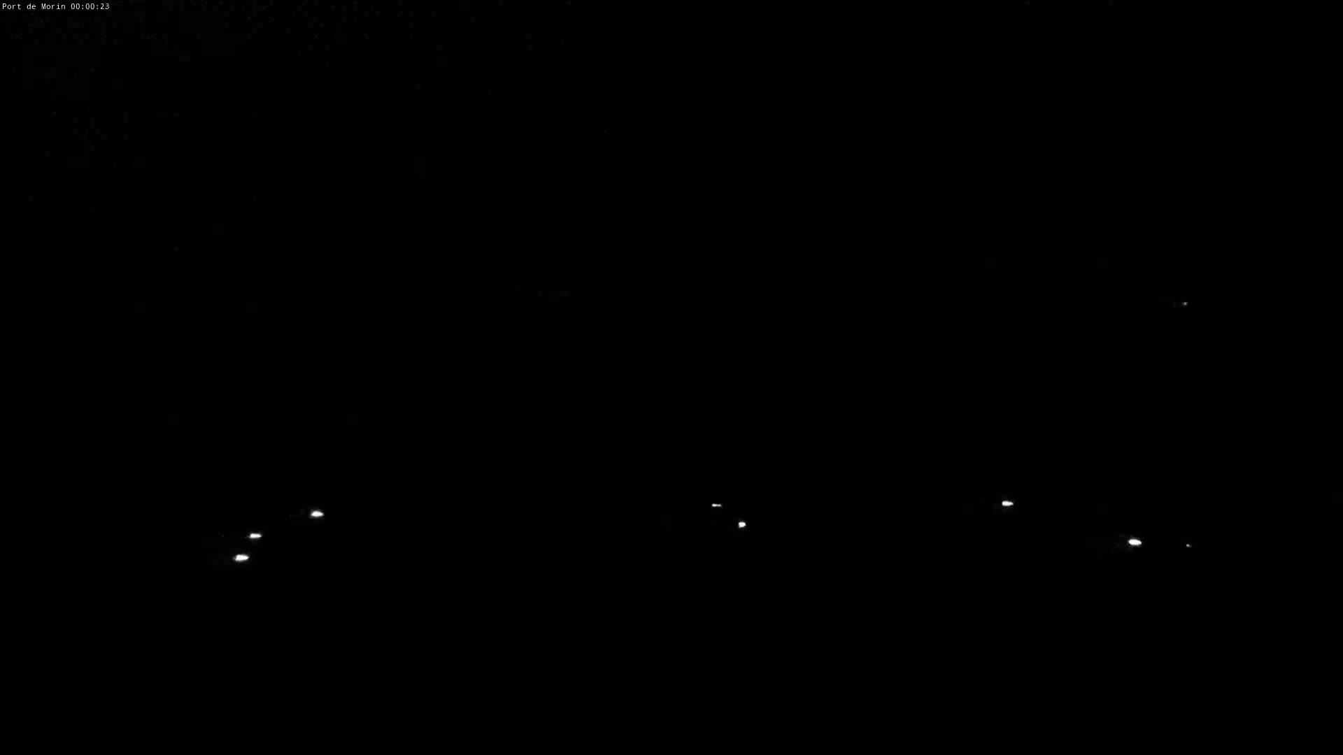 Several small, faint lights are visible in the inky blackness of night.