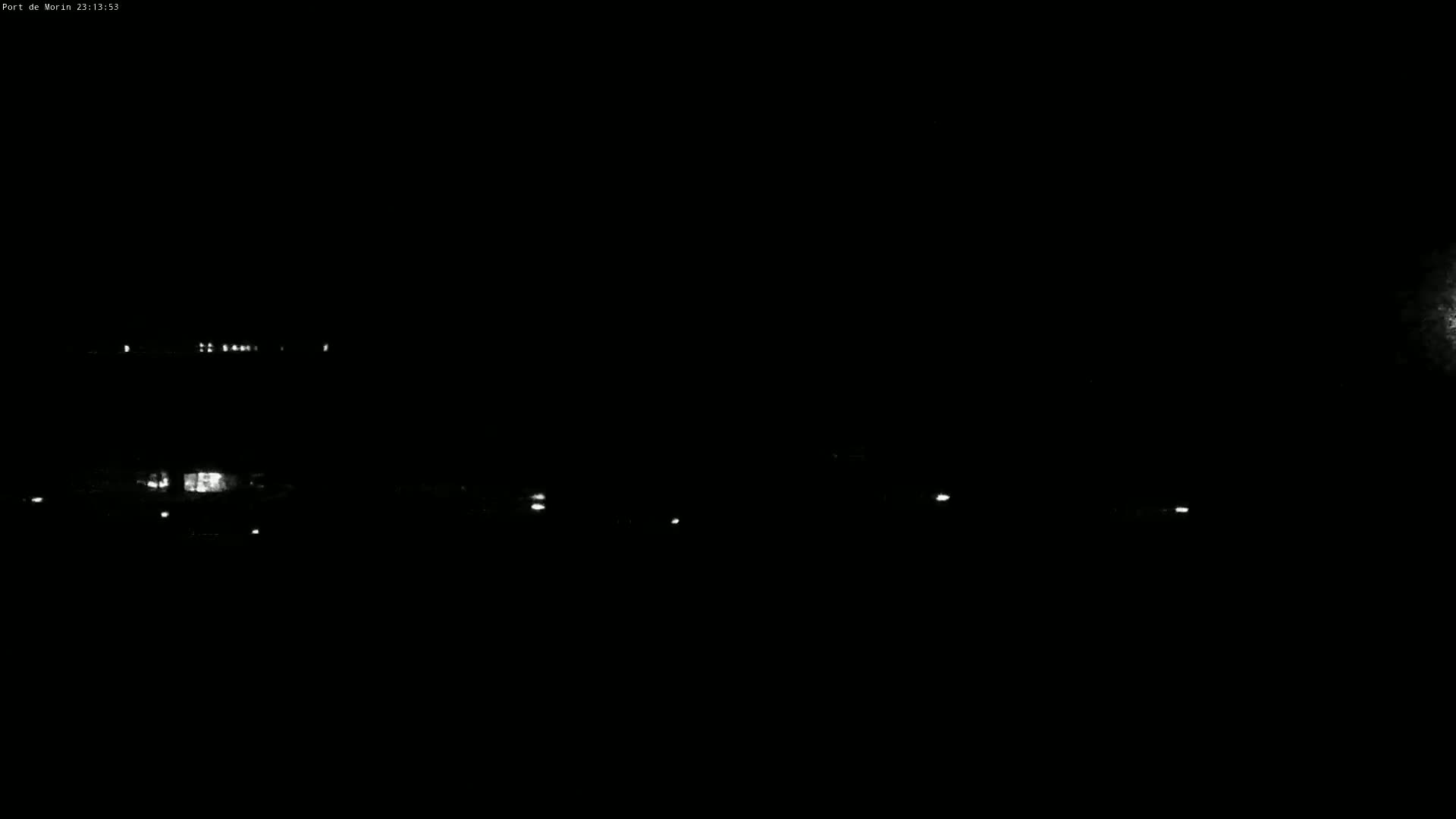 A nighttime long shot shows a dark landscape with a few faint lights in the distance.