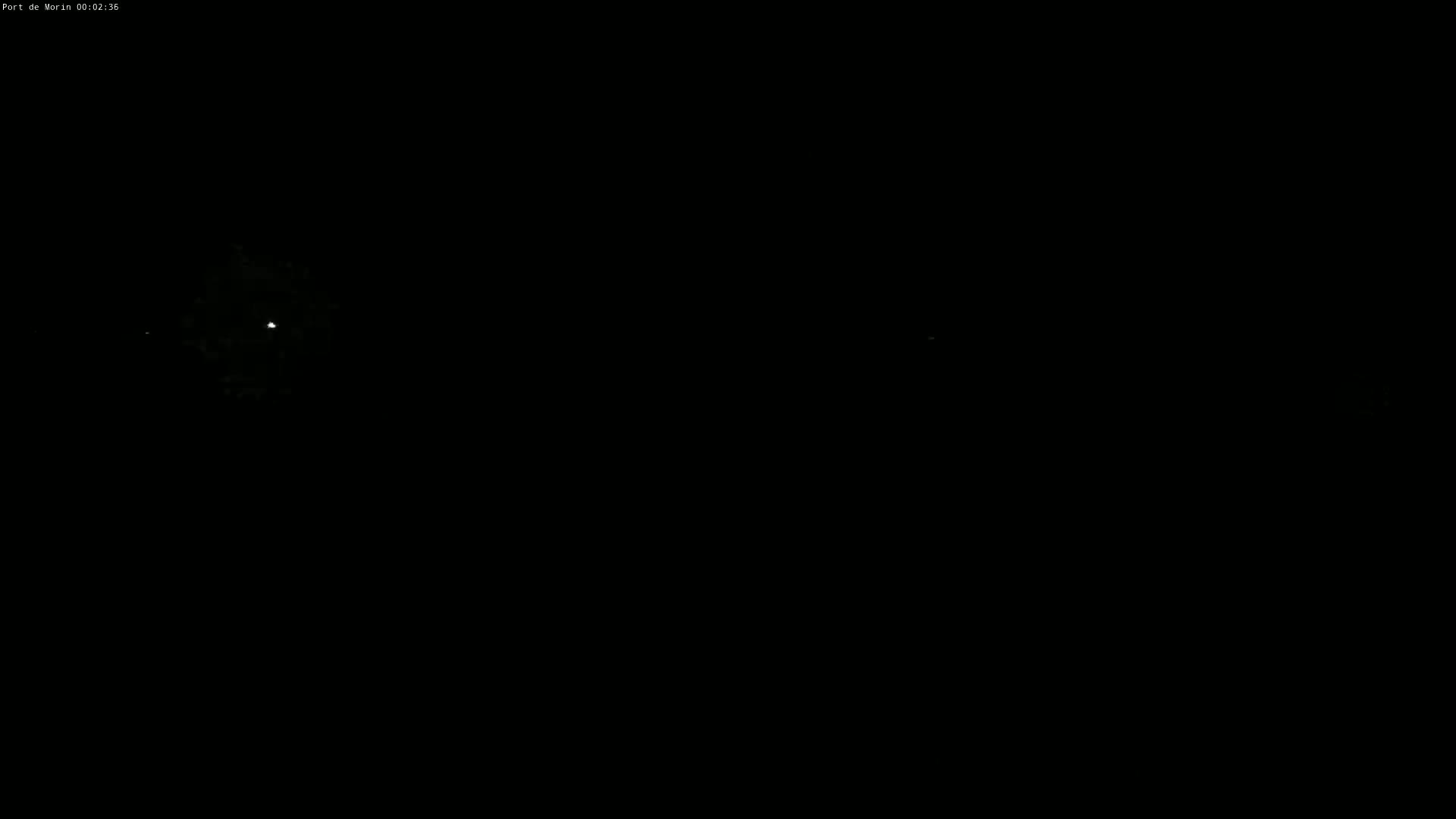 A bright light, possibly a distant light source or celestial body, is visible in a dark, nighttime scene.
