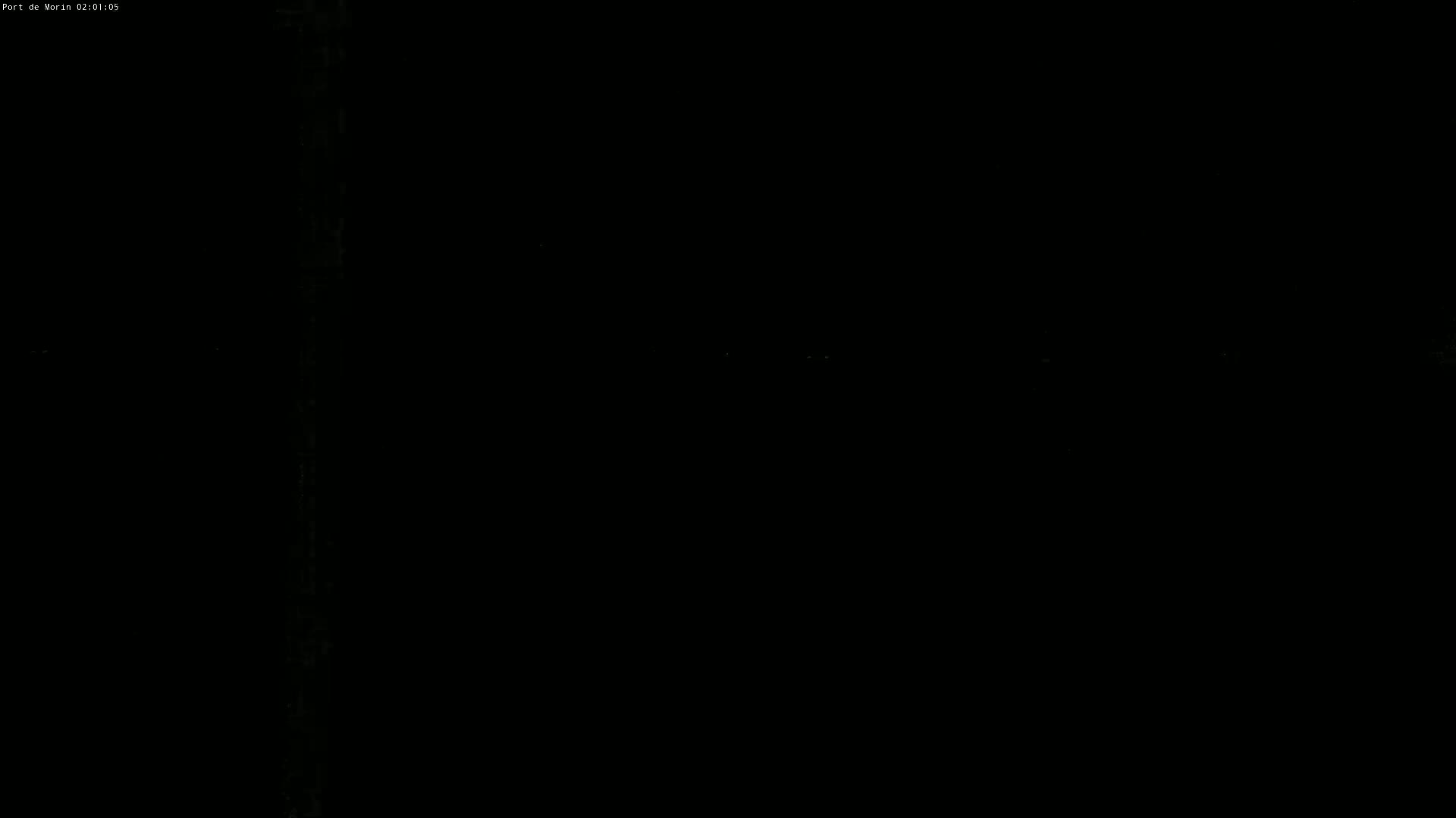 The image is almost entirely black, with a few faint, blurry lights visible in the distance.