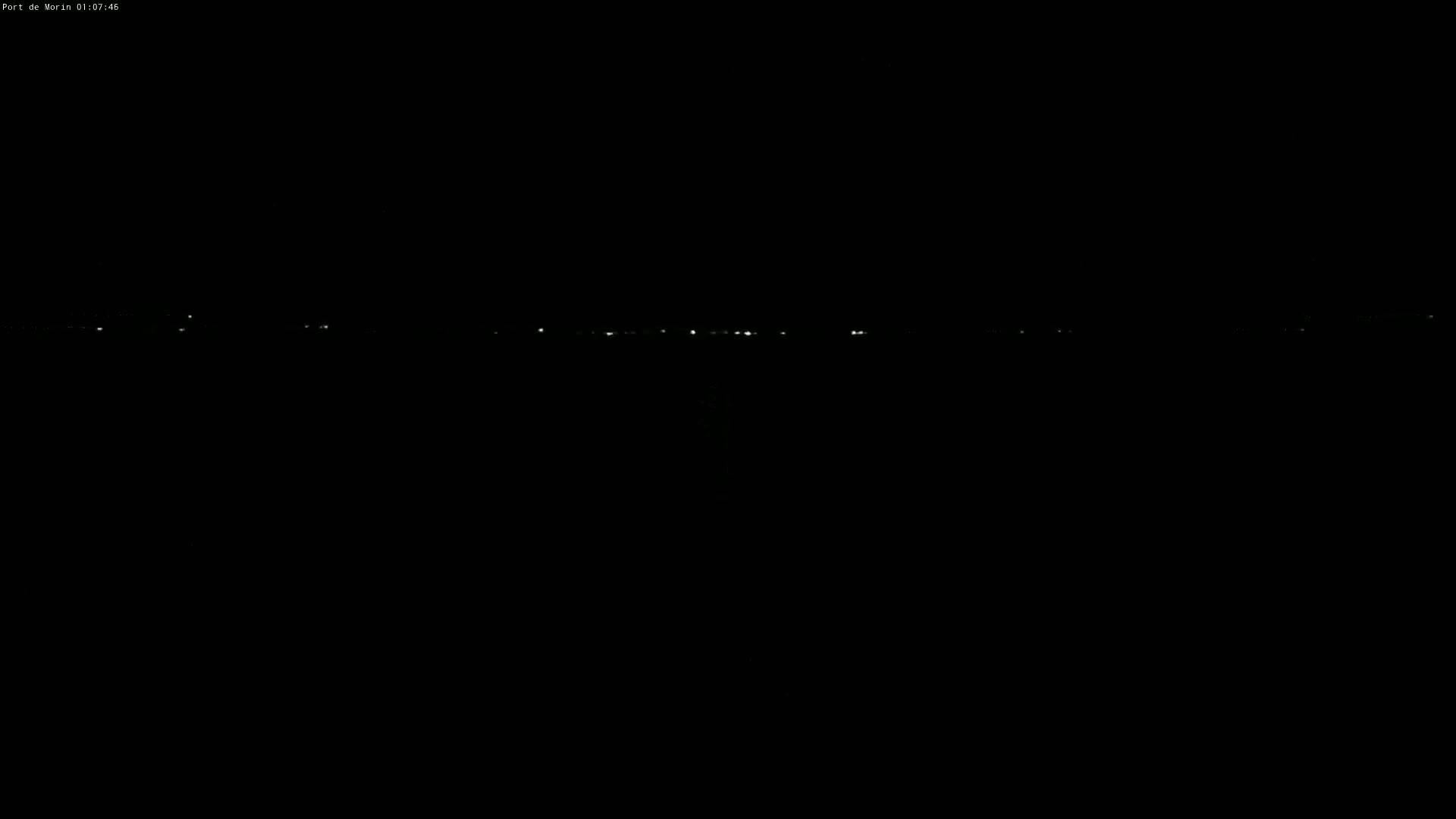 A distant line of faint lights is visible on a dark, nighttime horizon.