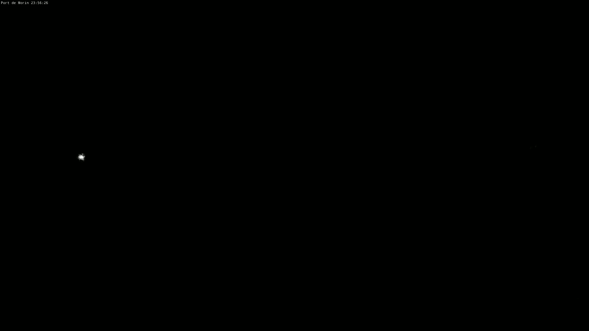 A nighttime image shows a bright point of light in a dark sky.