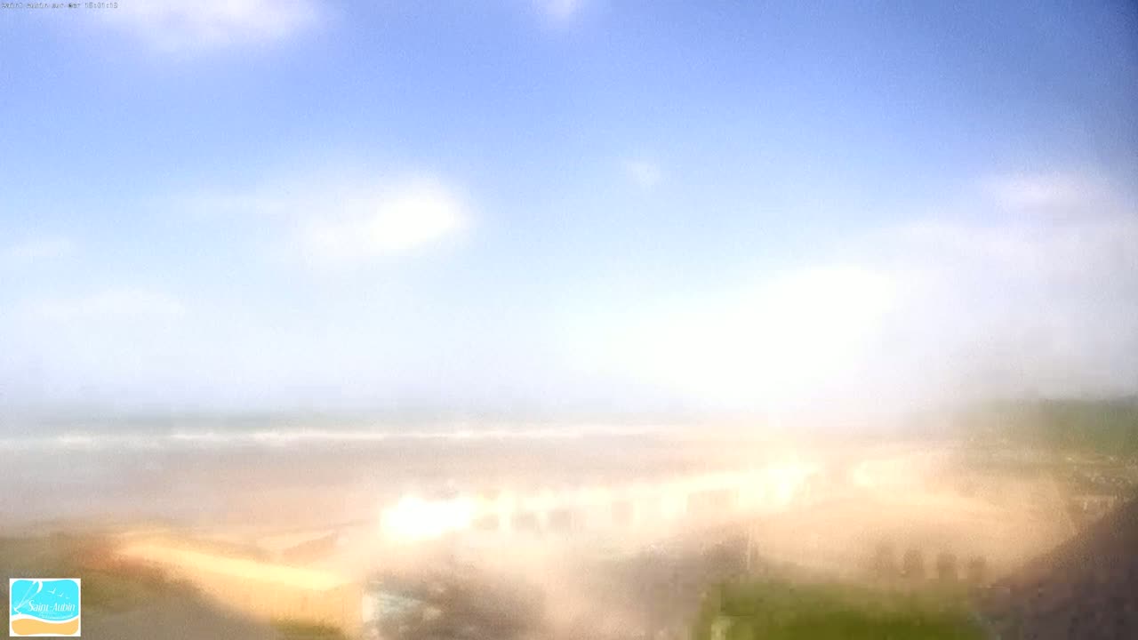 A hazy, partly cloudy day reveals a beach and ocean in the distance.