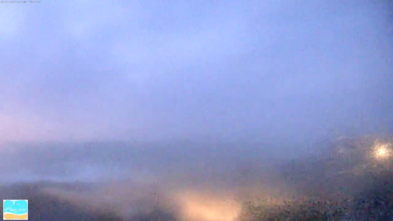 A hazy, light-purple landscape is visible under a mostly clear sky.