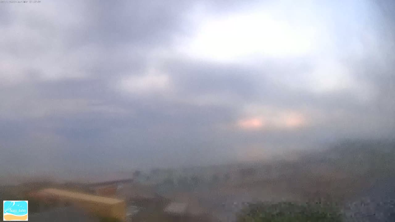 A hazy, overcast sky with a hint of light breaking through the clouds obscures the view of a distant landscape.