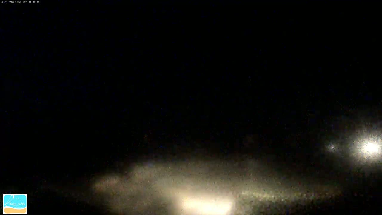 At night, vehicle headlights illuminate a hazy, dark landscape.
