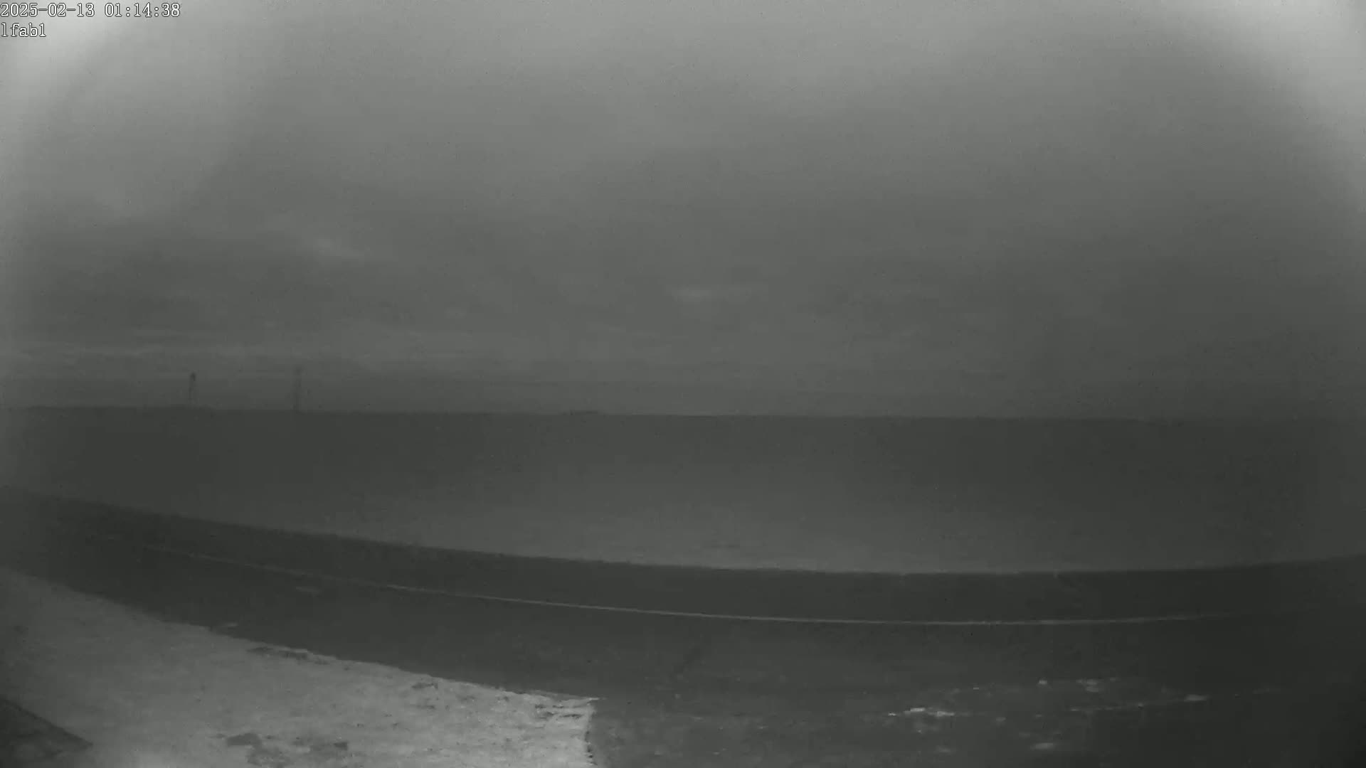 A flat, dark landscape is visible under an overcast sky.
