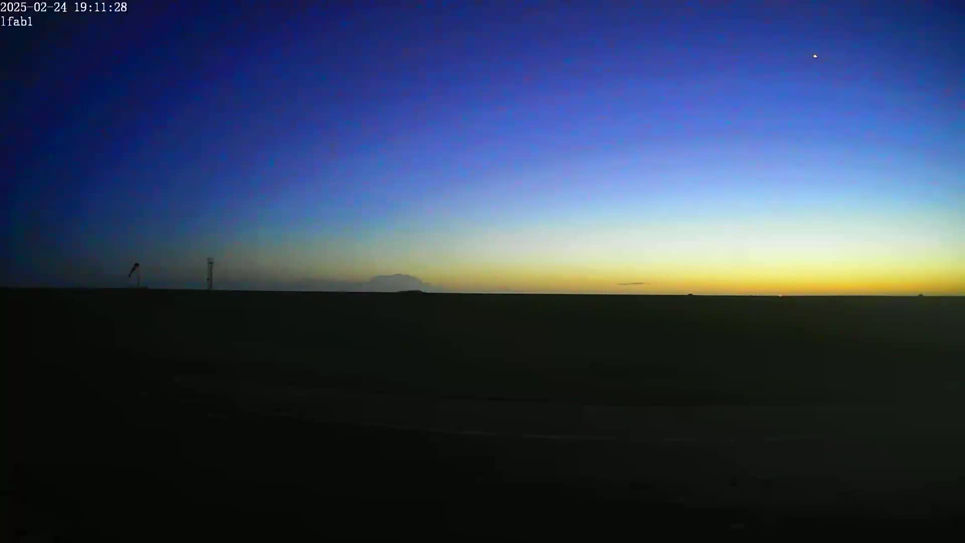 A dark landscape under a twilight sky shows a bright yellow and orange horizon with a single bright star visible in the deepening blue.
