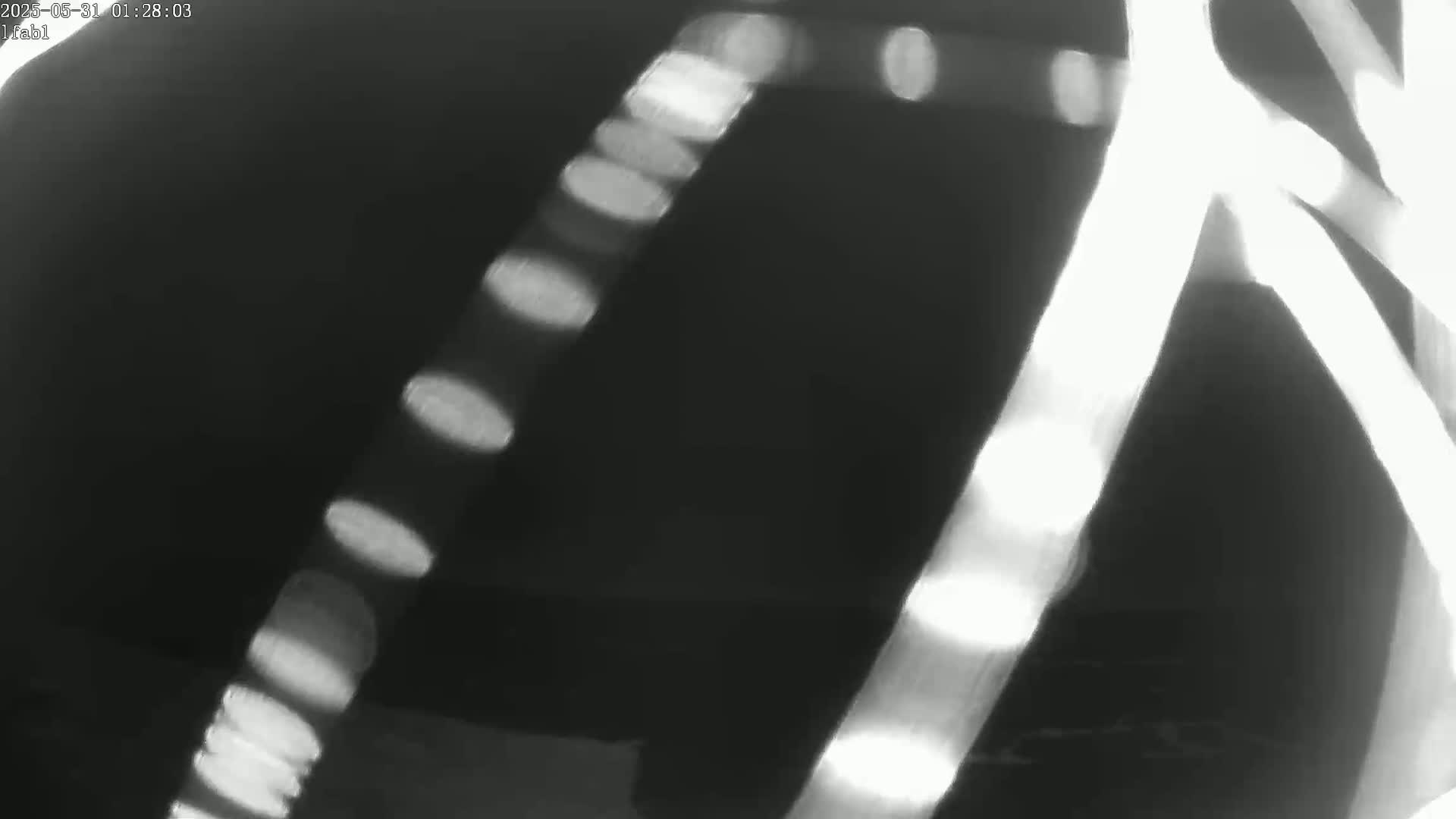 Blurred streaks of light appear in a dark, nighttime setting.