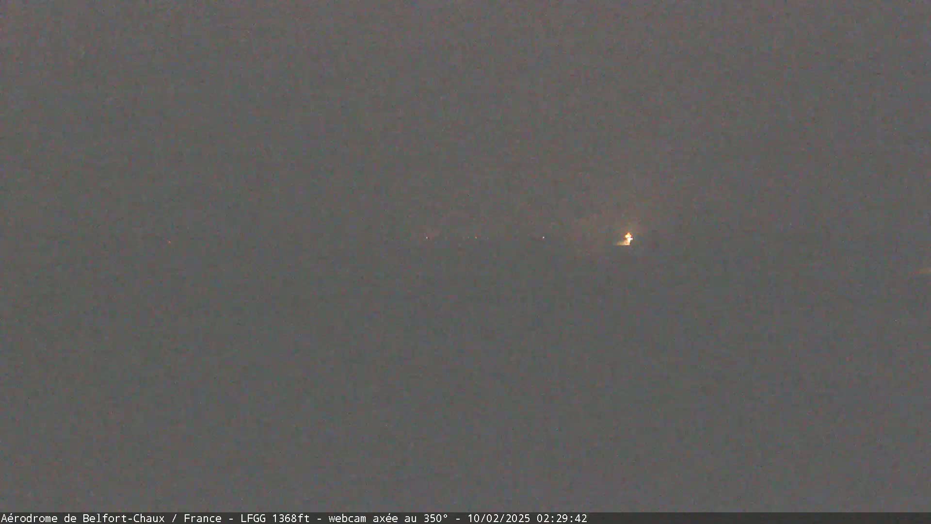 A dimly lit, dark landscape is visible under a night sky.