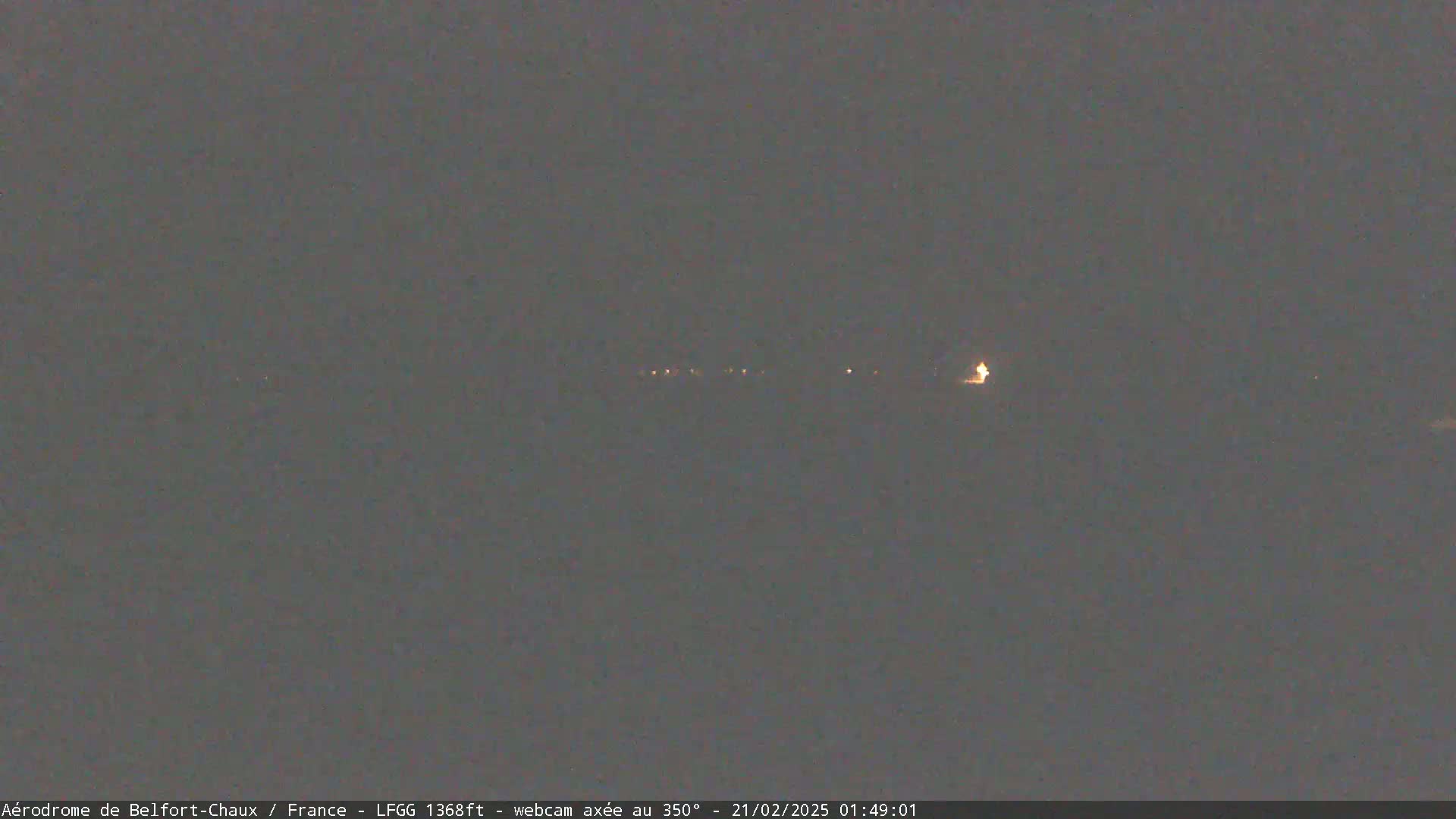 A nighttime long shot shows a dimly lit landscape with a few distant lights.