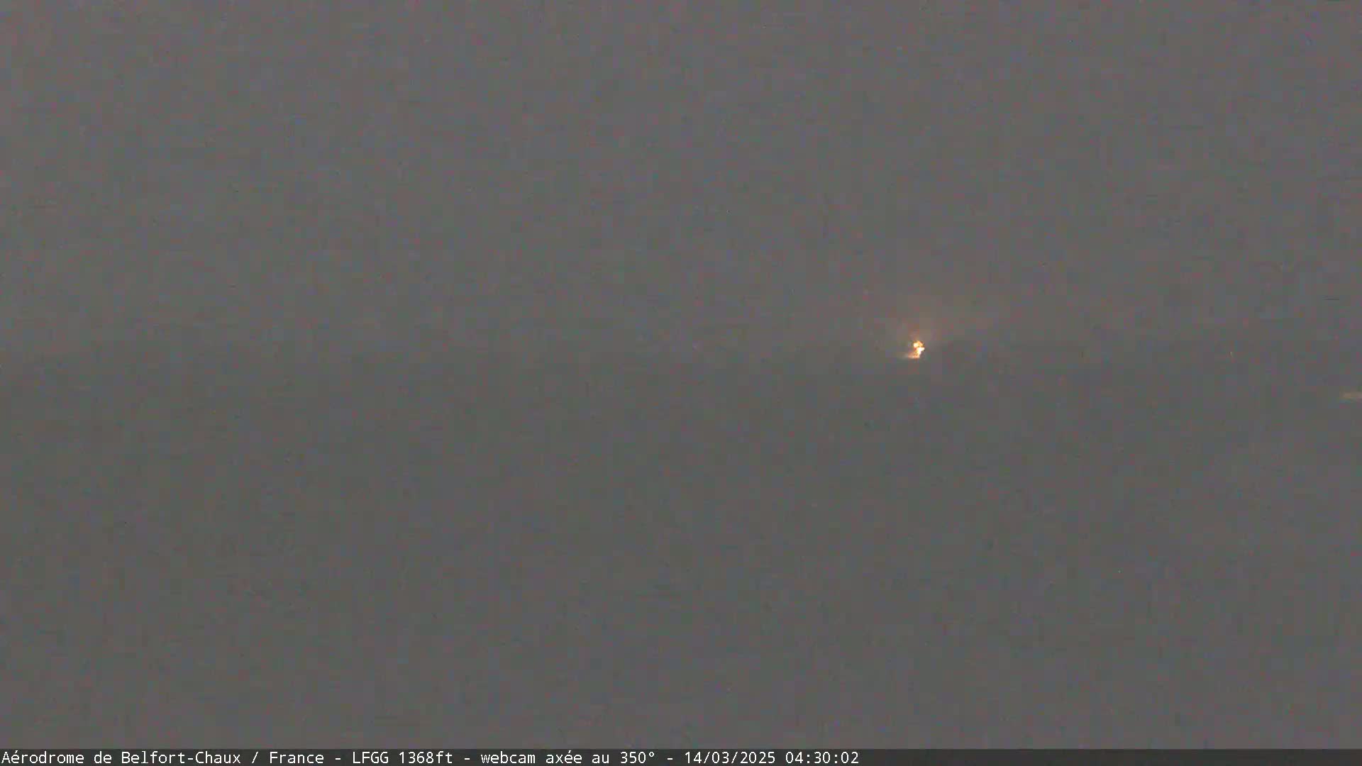A dimly lit, hazy scene shows a faint light in the distance.