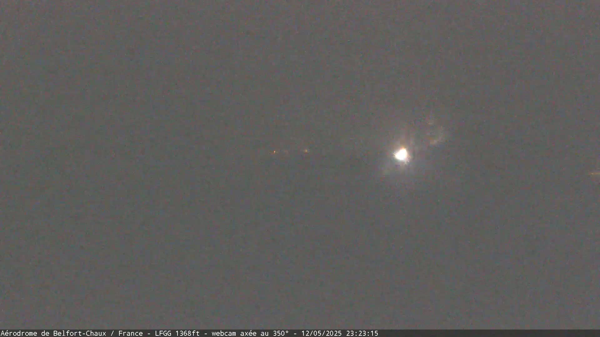 A bright moon is visible in a mostly clear, dark night sky.