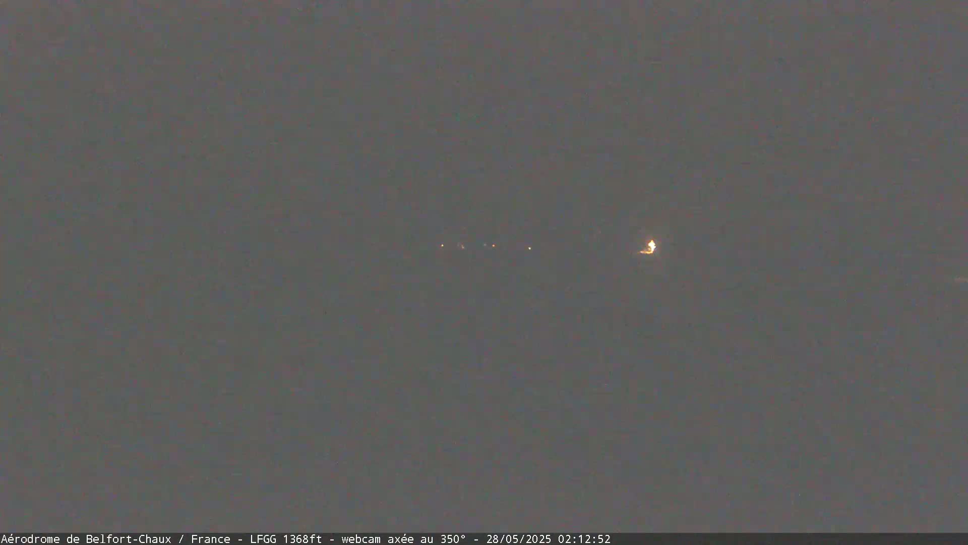 A dark, nighttime scene shows a few distant, faint lights.