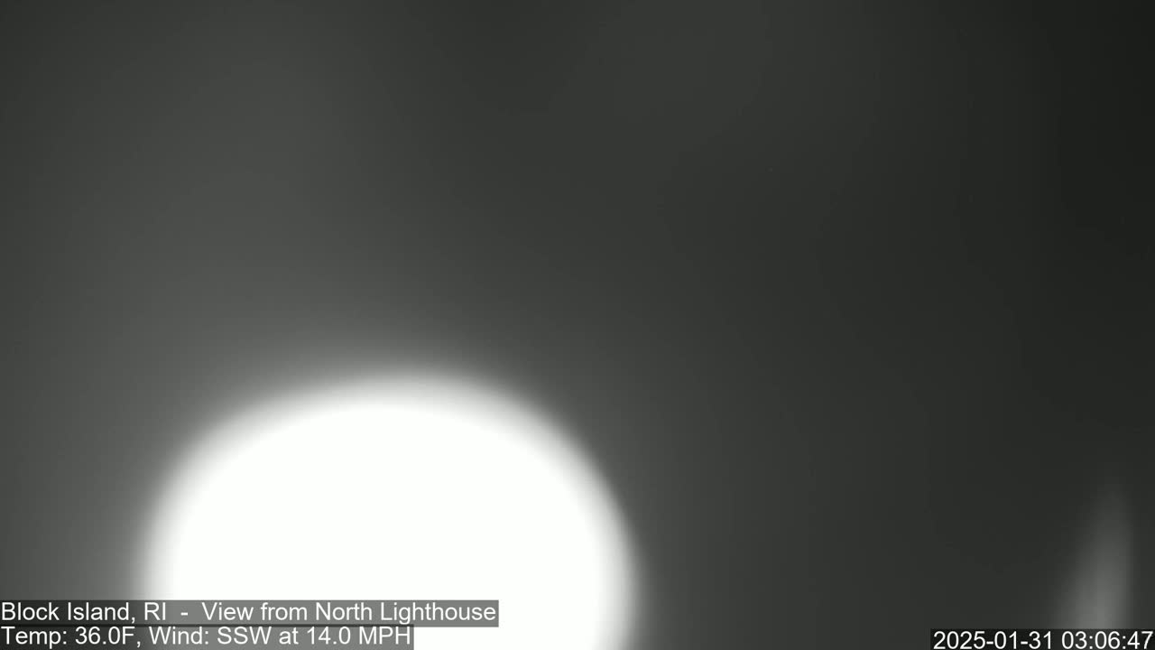 A bright white light dominates a dark, overcast sky.