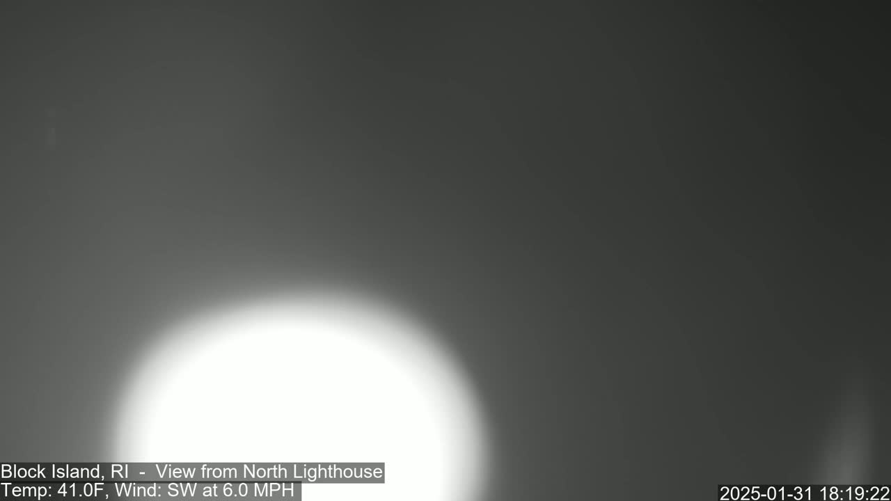 A bright, blurry white light dominates the lower portion of a dark gray, overcast sky.