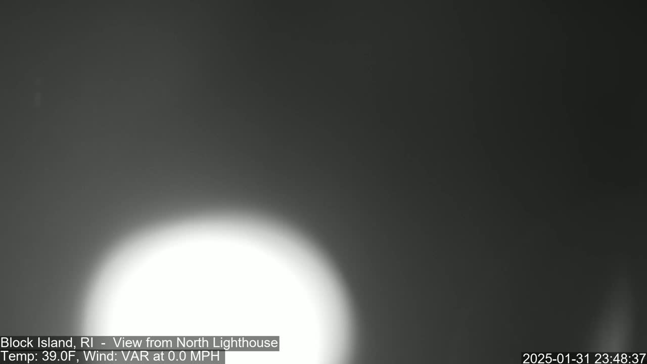 A bright, blurry white light dominates the lower center of a dark, nighttime image.