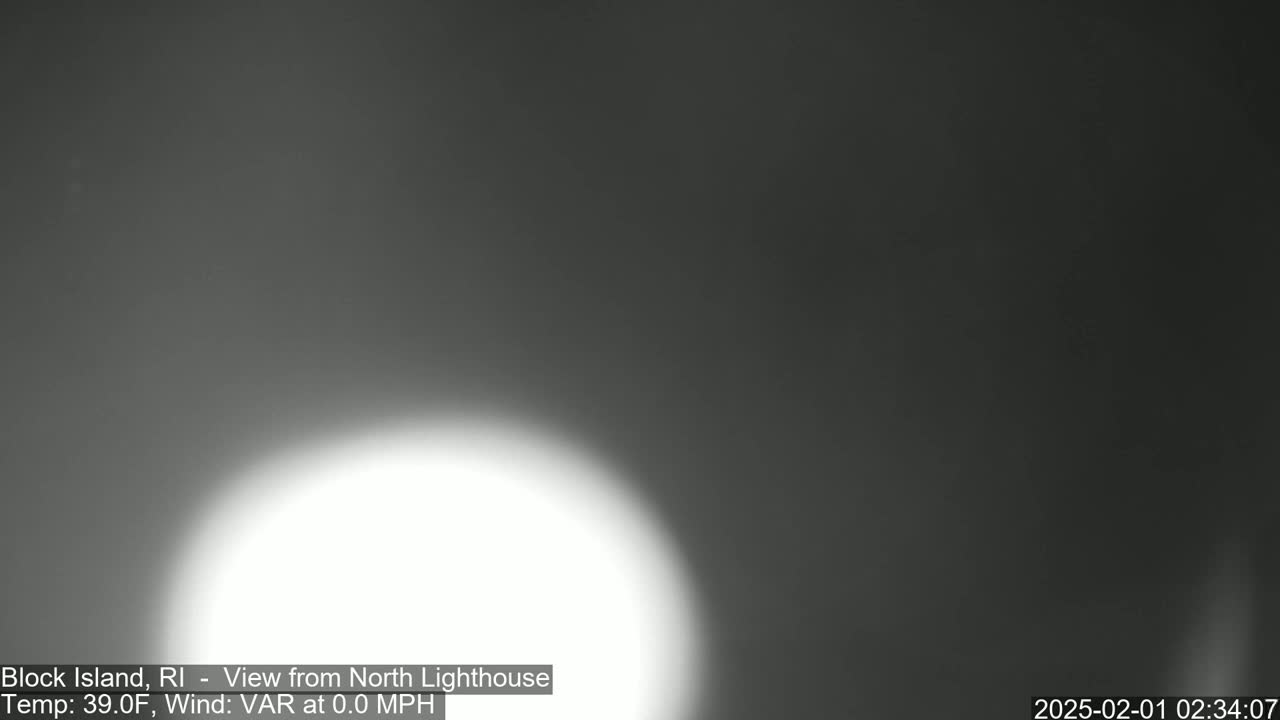 A bright, blurry white light dominates the lower center of a dark gray, overcast outdoor scene.