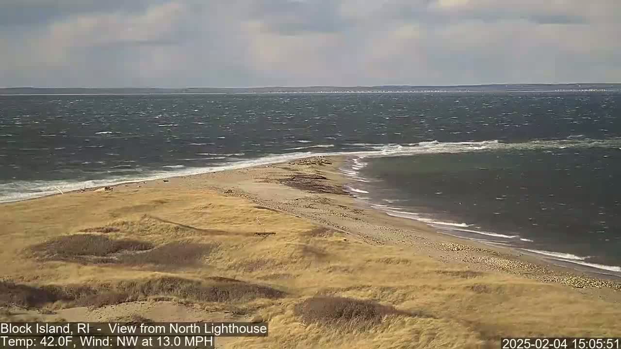 A windy, 42°F day shows a view of a sandy beach and a narrow spit of land jutting out into a choppy ocean.