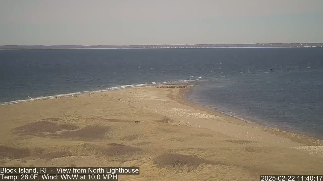 A sandy beach and a calm ocean are visible under a clear sky.