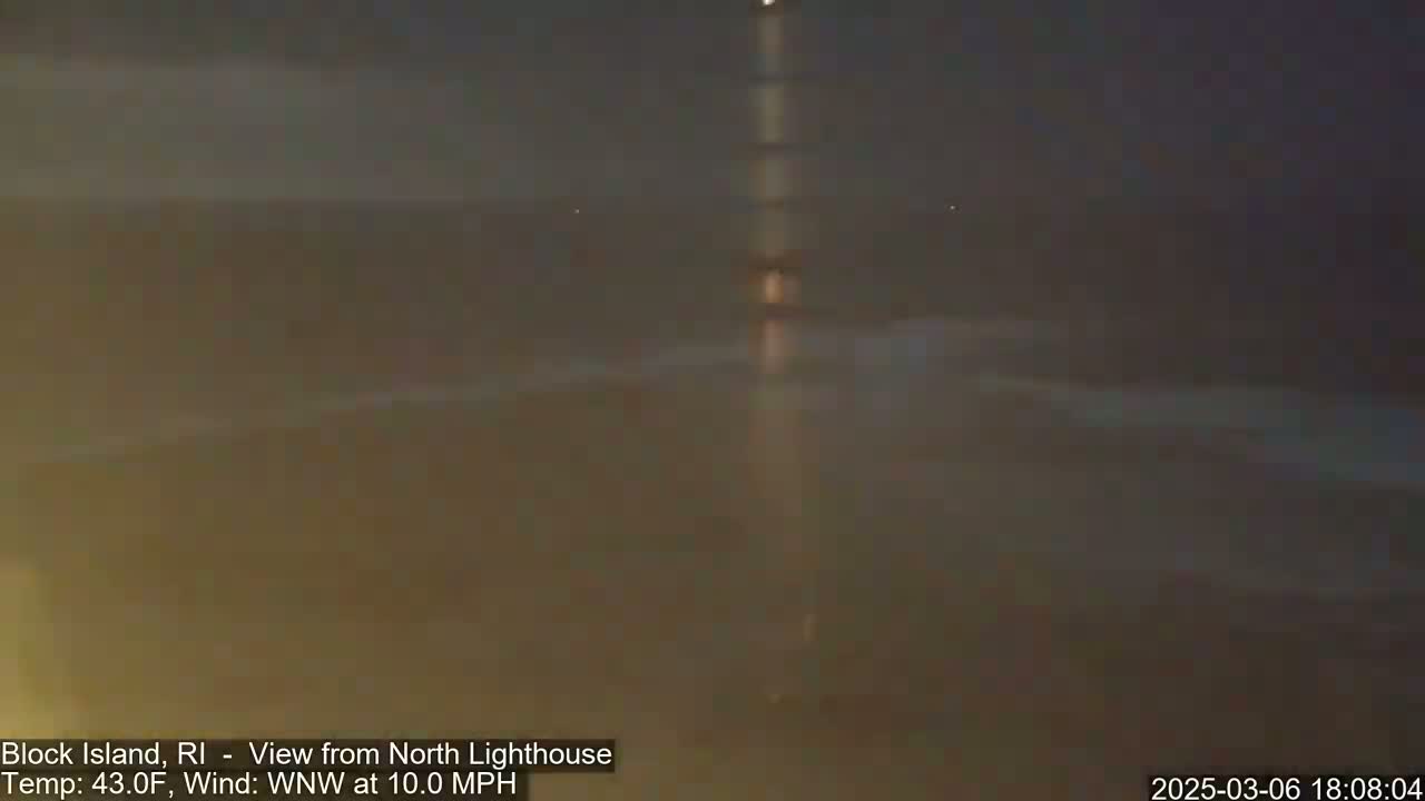 A dark, blurry nighttime coastal scene shows a body of water under a mostly clear sky with a 10 mph wind.