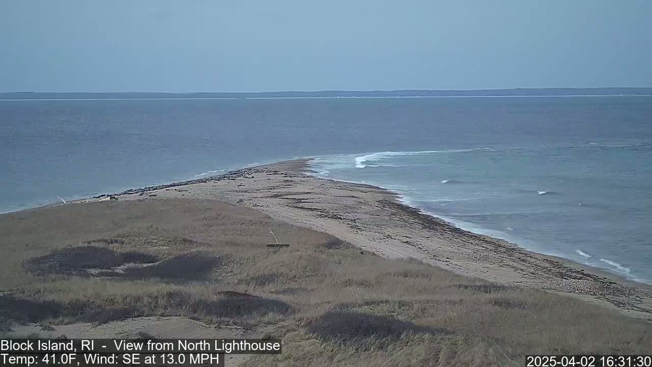 A sandy shoreline with a southeastern wind at 13 mph and a temperature of 41°F meets a calm ocean under a clear sky.