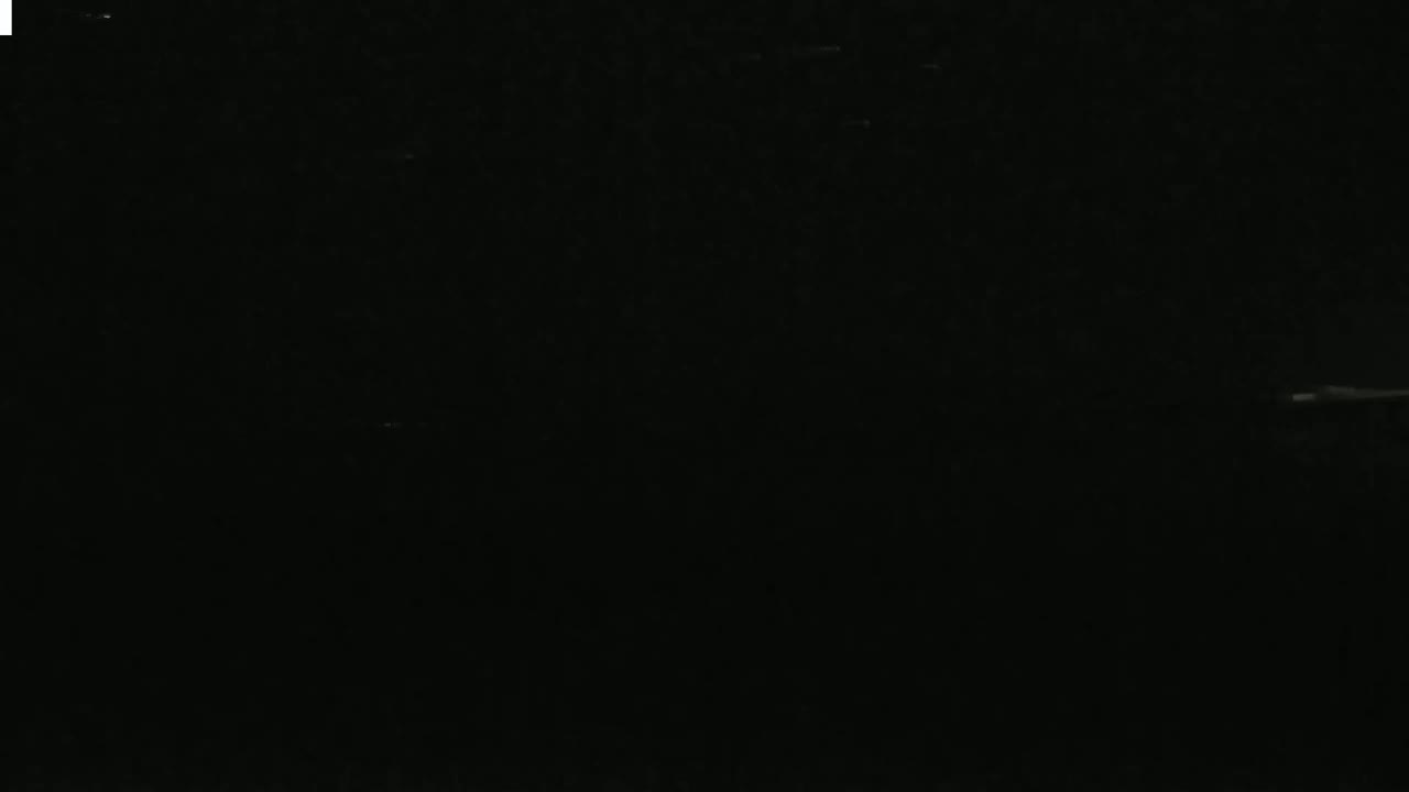 The image shows a mostly black screen with faint, speckled white noise.