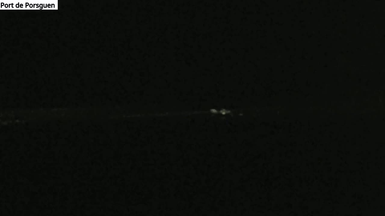 A dimly lit, dark scene shows a faint, horizontal line of light on the horizon at night.