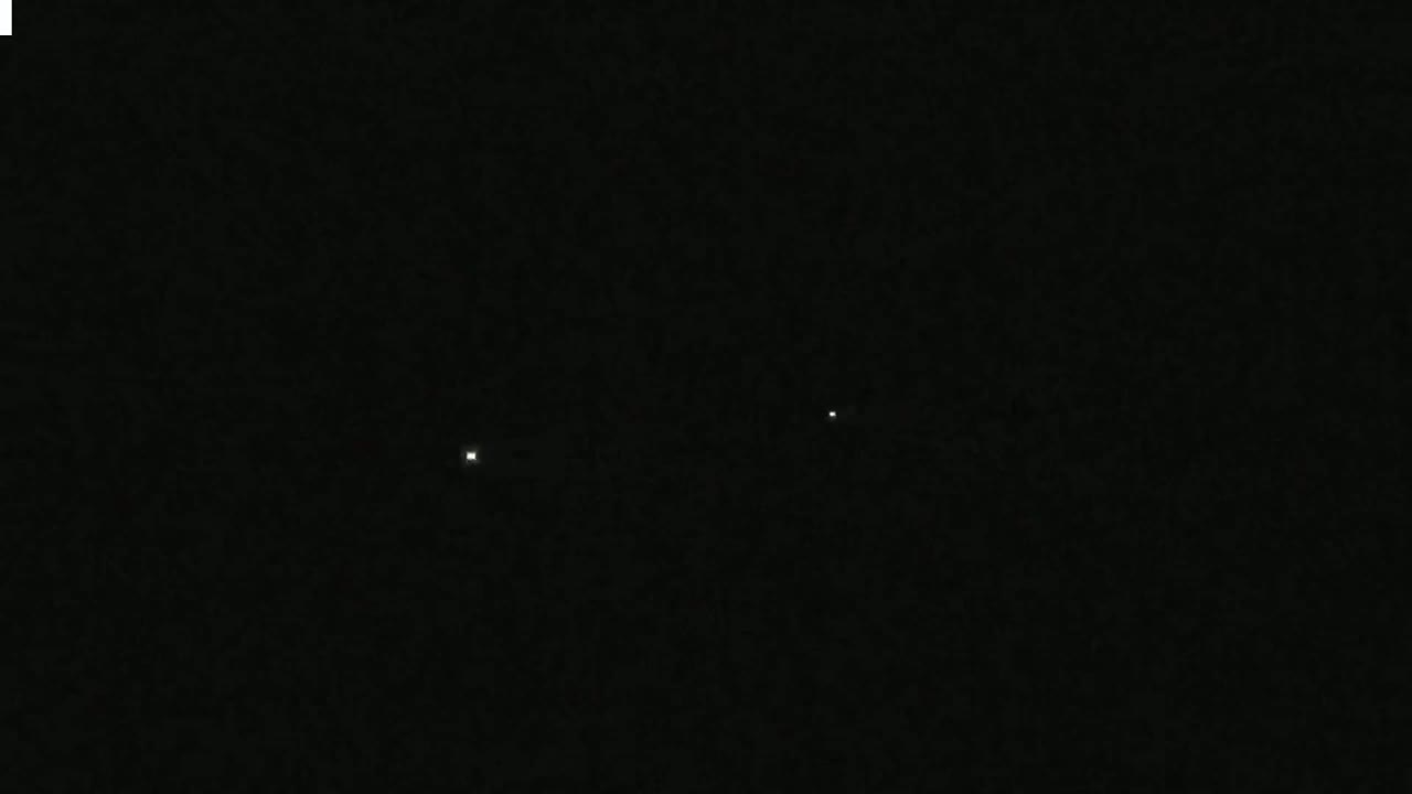 Three faint points of light are visible in a dark, night sky.