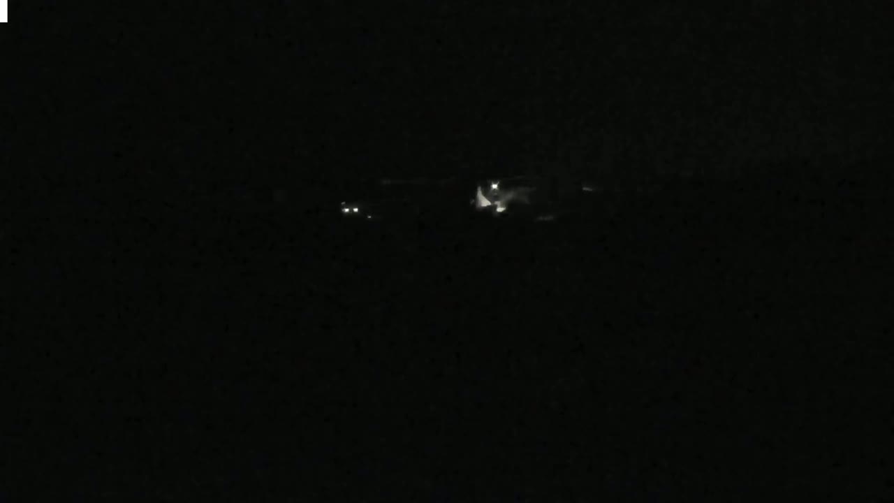 Faint lights are visible in the distance at night.