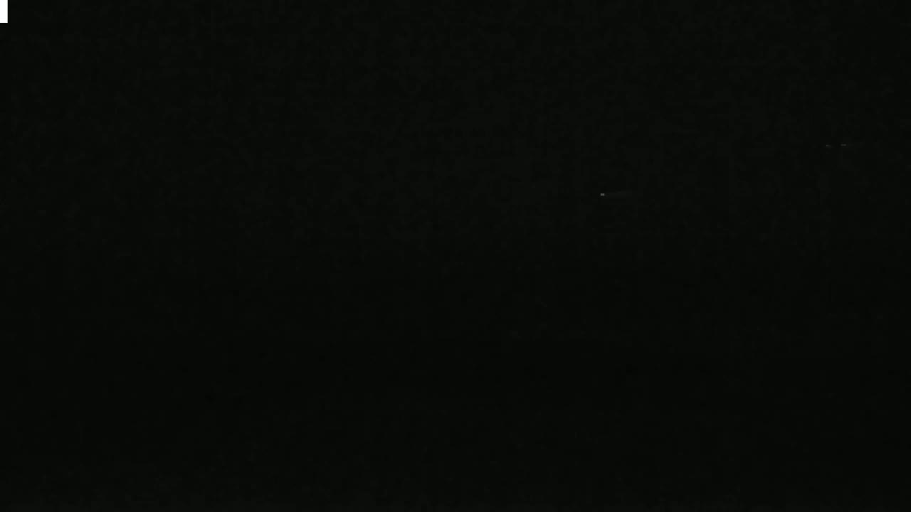 The image is almost entirely black, with a few faint, indistinct specks of light.