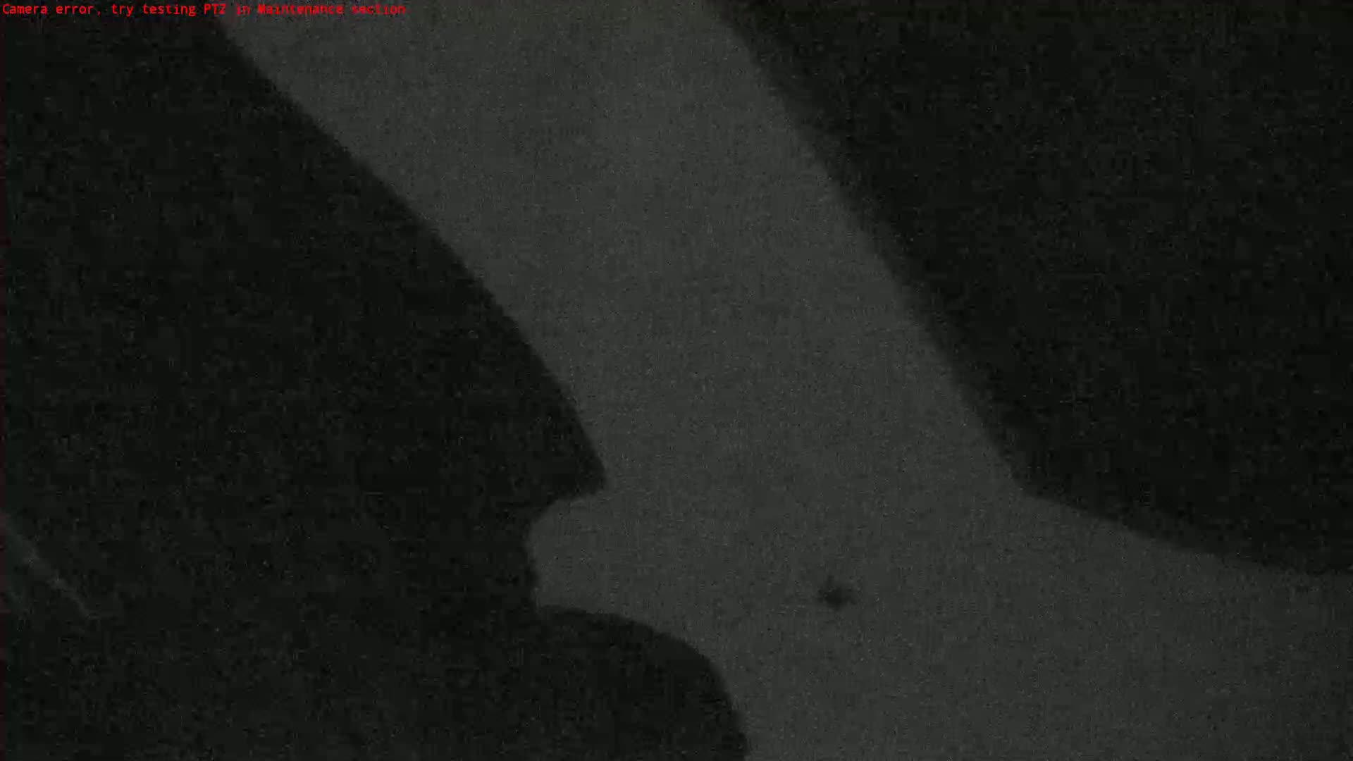 A grainy, dark image shows a shadowy figure in the lower left corner against a mostly dark background.