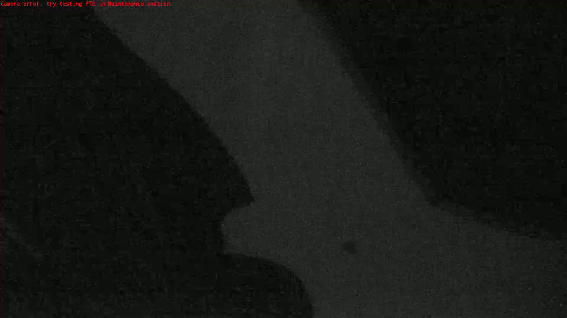A grainy, dark image shows indistinct shapes, possibly shadows or low-light objects.