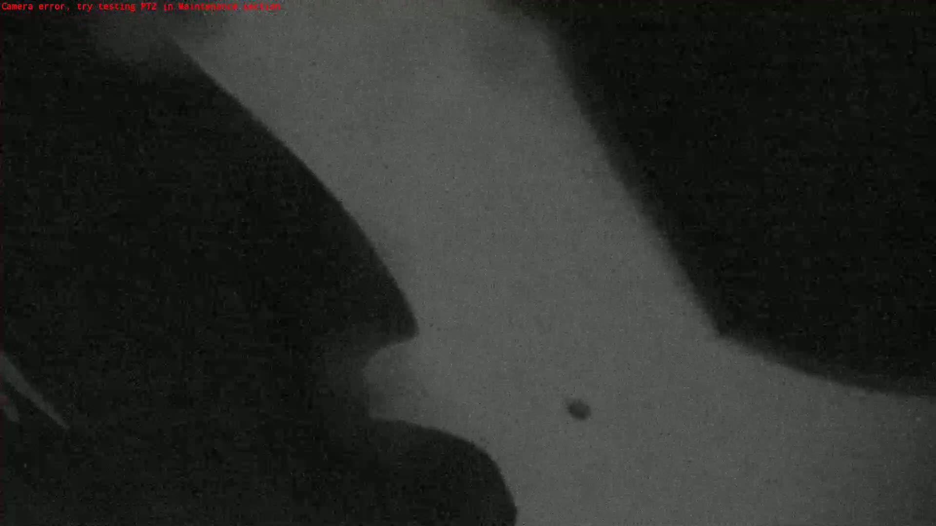 A grainy, dark gray image shows indistinct shapes and shadows, possibly indicating a low-light or nighttime scene.