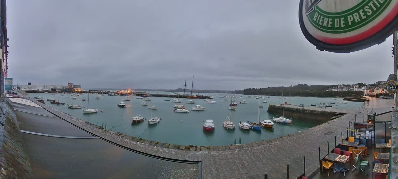 A harbor filled with numerous small boats under an overcast sky.