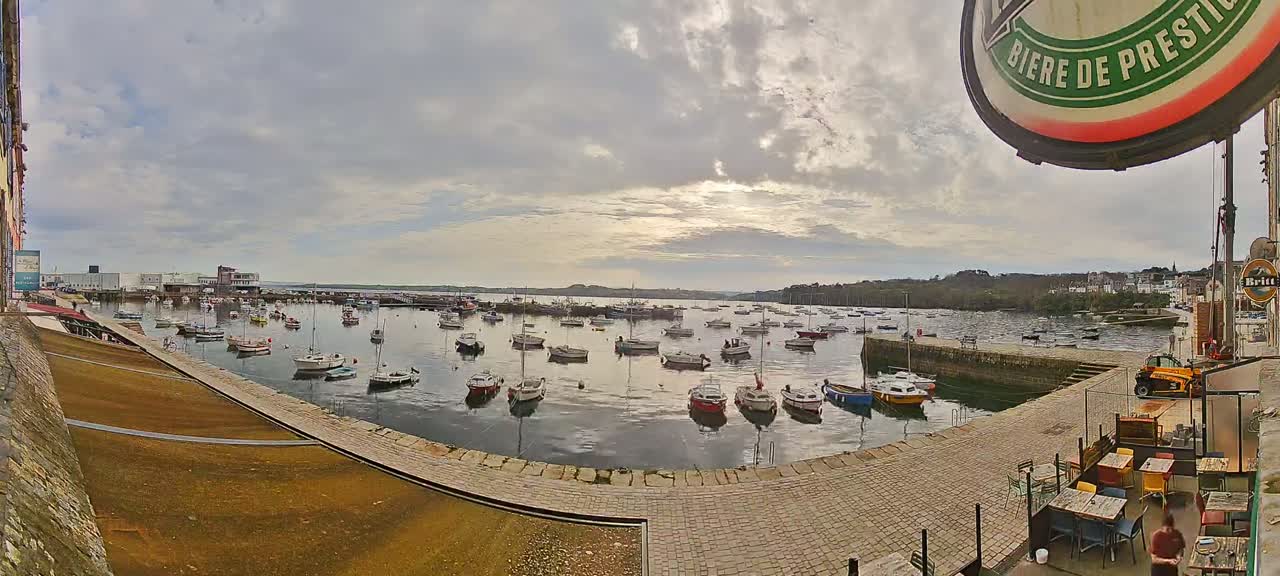 A harbor filled with numerous small boats under a cloudy sky.