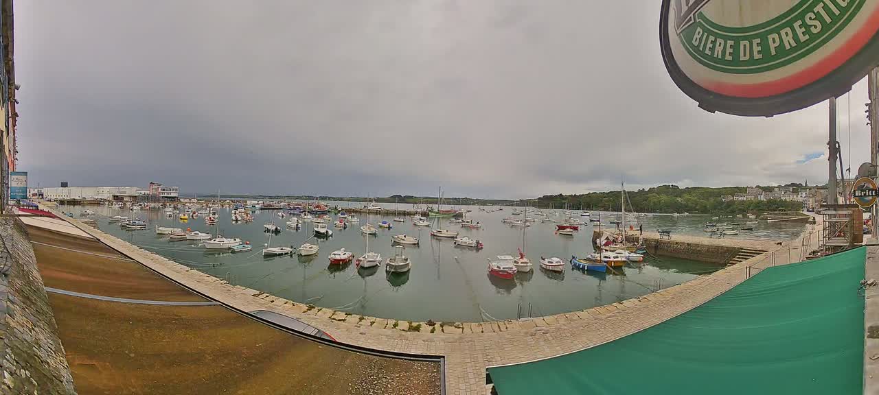 A harbor filled with numerous small boats under an overcast sky.