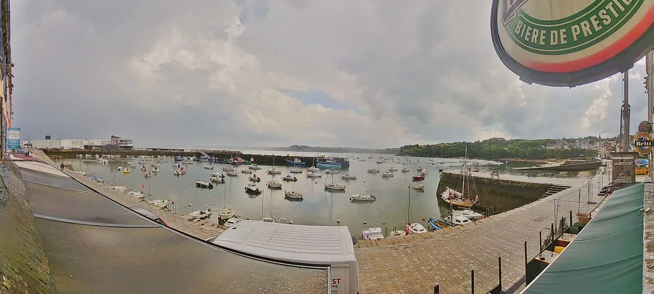 A harbor filled with numerous boats under a cloudy sky.