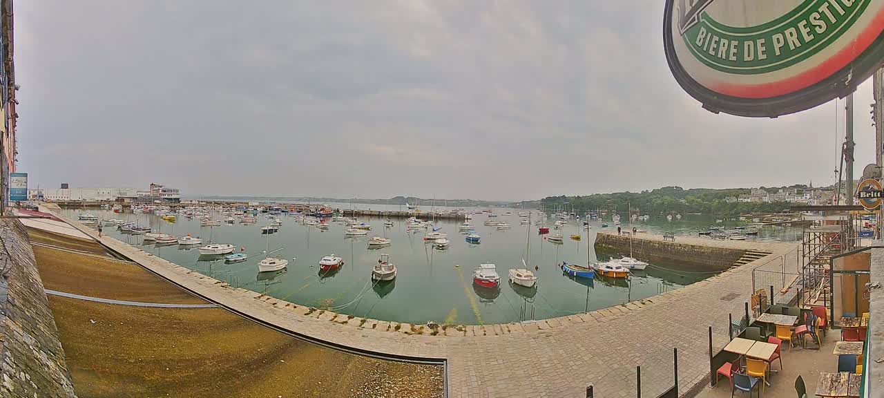 A harbor filled with numerous small boats under an overcast sky.
