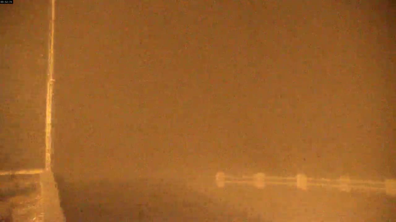 A blurry image shows a bright vertical line next to a hazy, brownish-orange landscape with indistinct objects in the lower right.