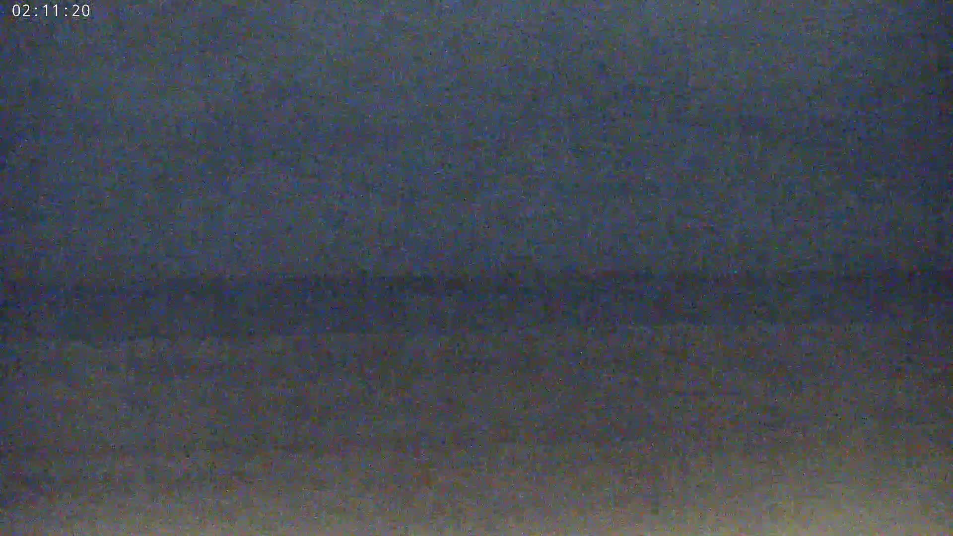 A dark, blurry image shows a mostly featureless landscape at night.
