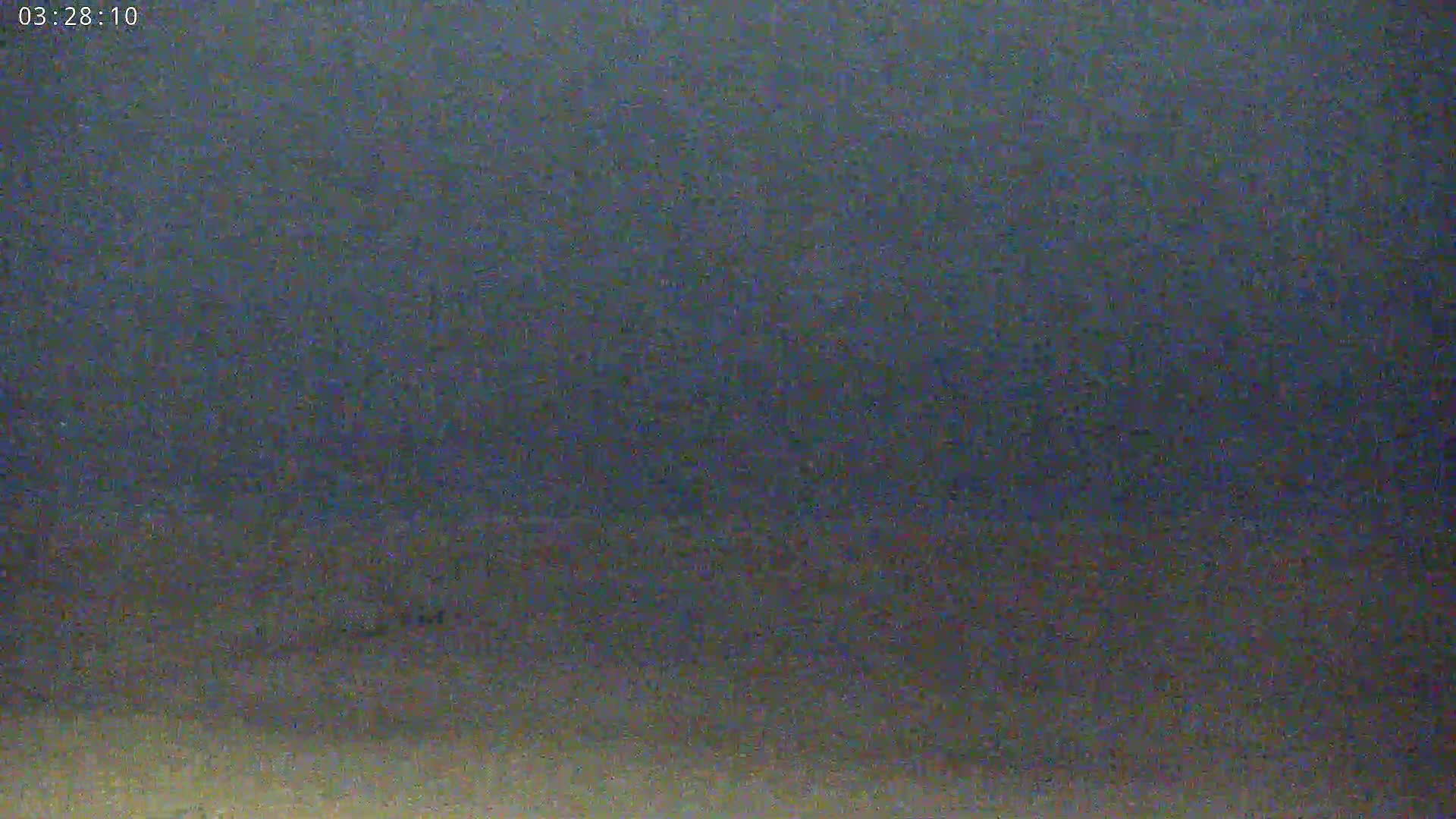 The image shows a dark, grainy, and blurry view of what appears to be an overcast or nighttime sky.
