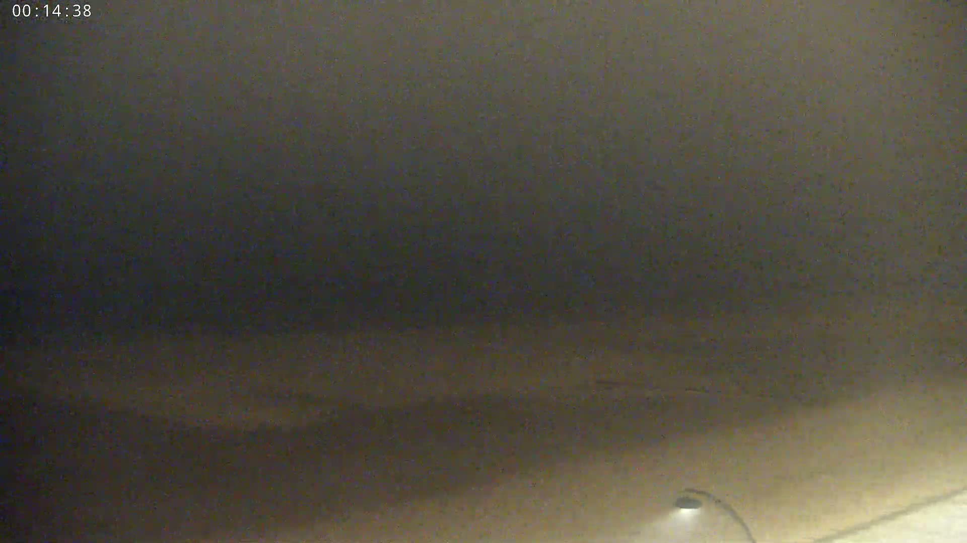 A low-light, blurry image shows a dark, possibly nighttime scene with a faintly visible light source at the bottom.