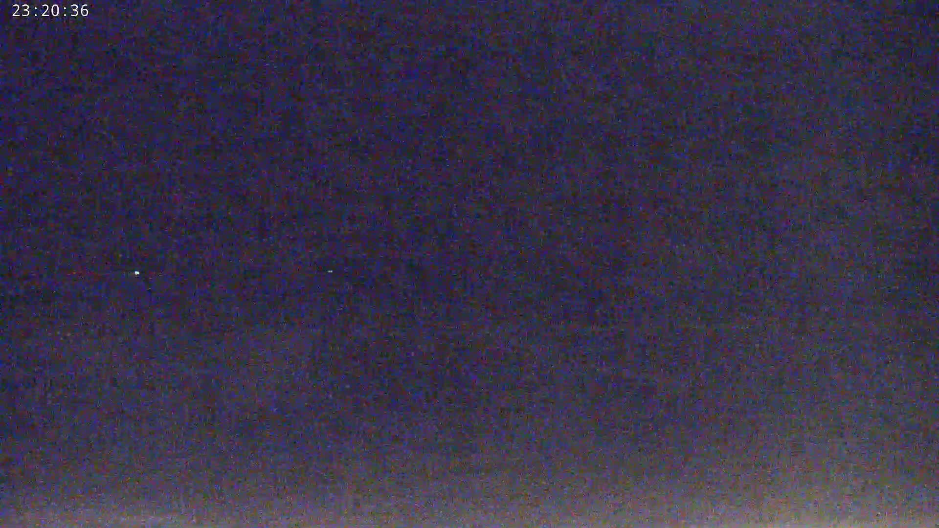 The image shows a dark, nighttime sky with a few faint points of light.