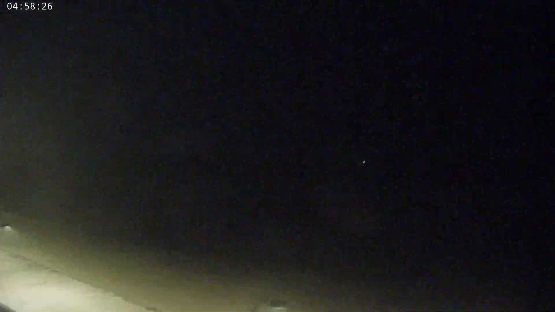 A dark night sky shows a few faint stars near the horizon, with a slightly brighter area at the bottom of the frame.