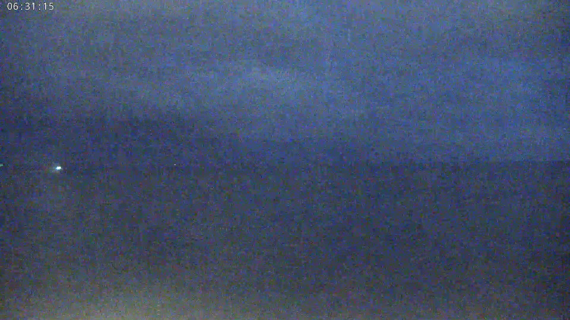 A dark blue, possibly nighttime, sky is shown over a dark body of water.
