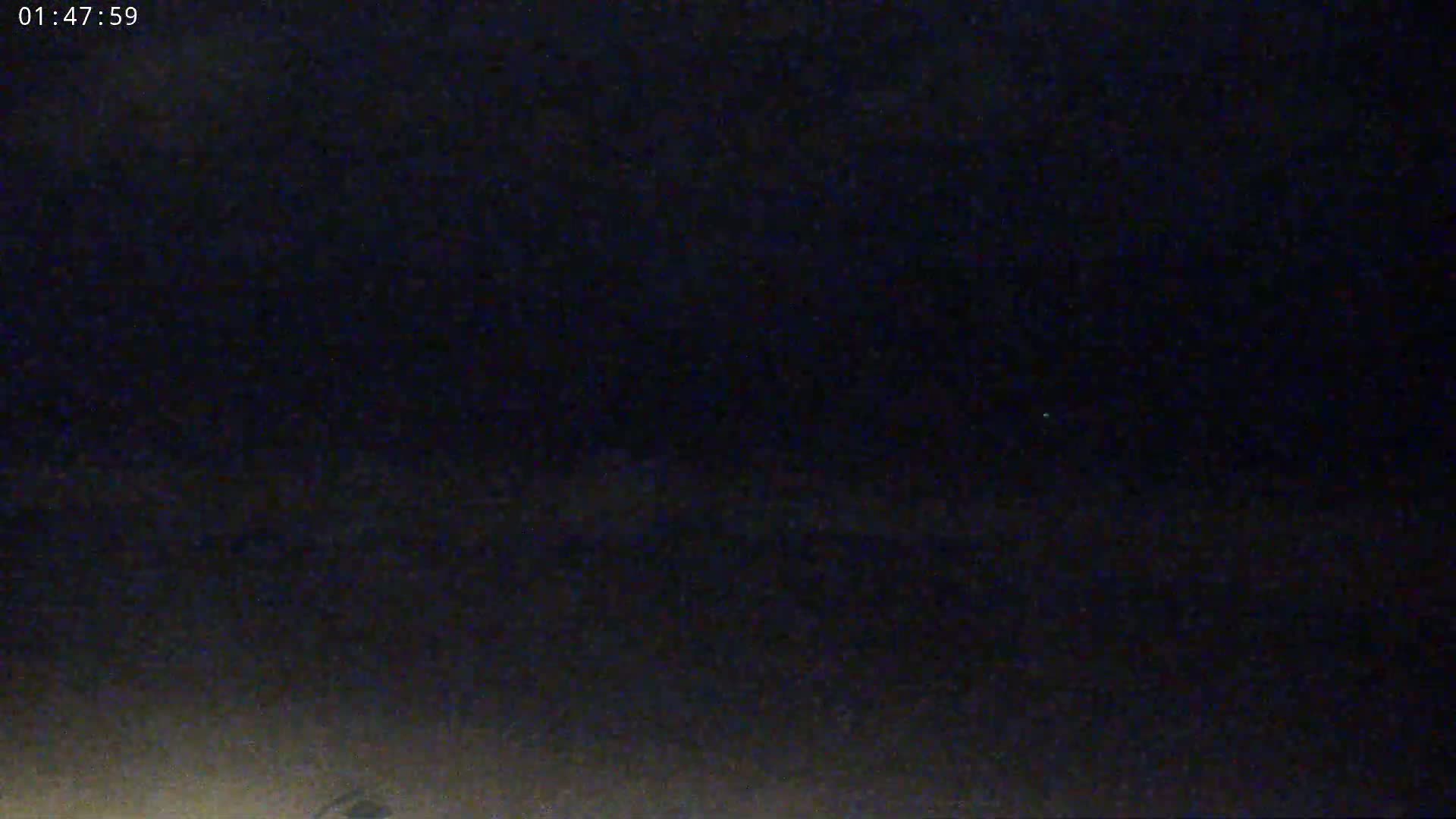 A dark, nighttime scene shows a dimly lit ground with a nearly black sky.