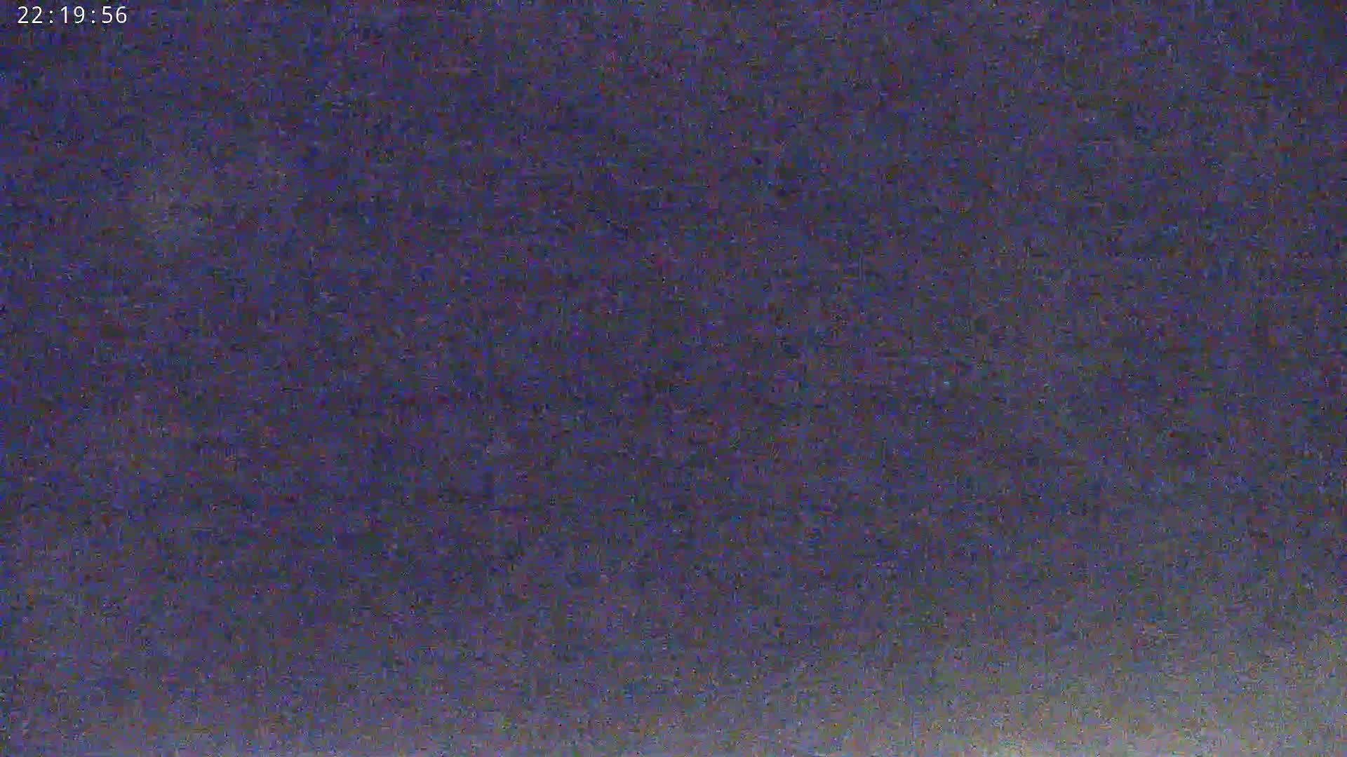 The image shows a dark, grainy, and blurry view of an outdoor scene at night.