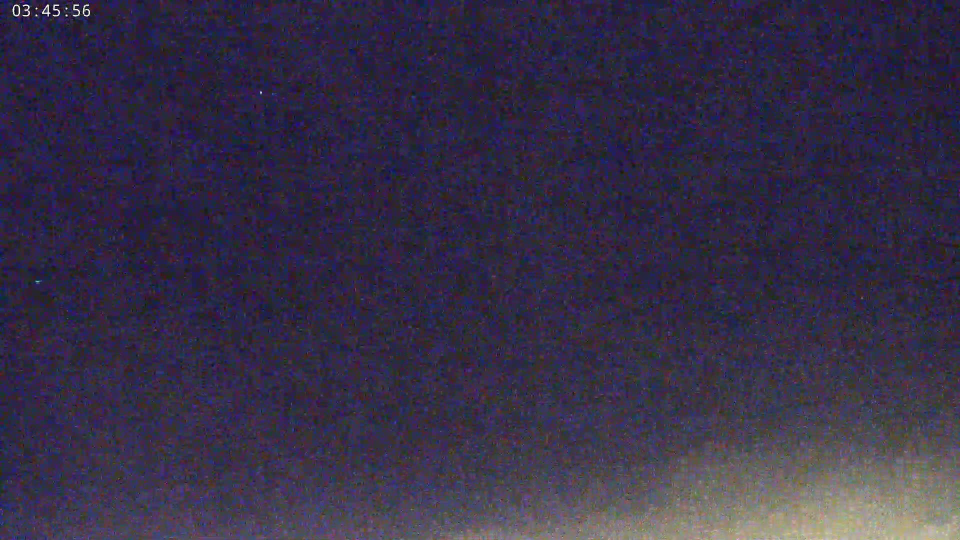 A nighttime image shows a dark purple sky with a slightly lighter horizon.